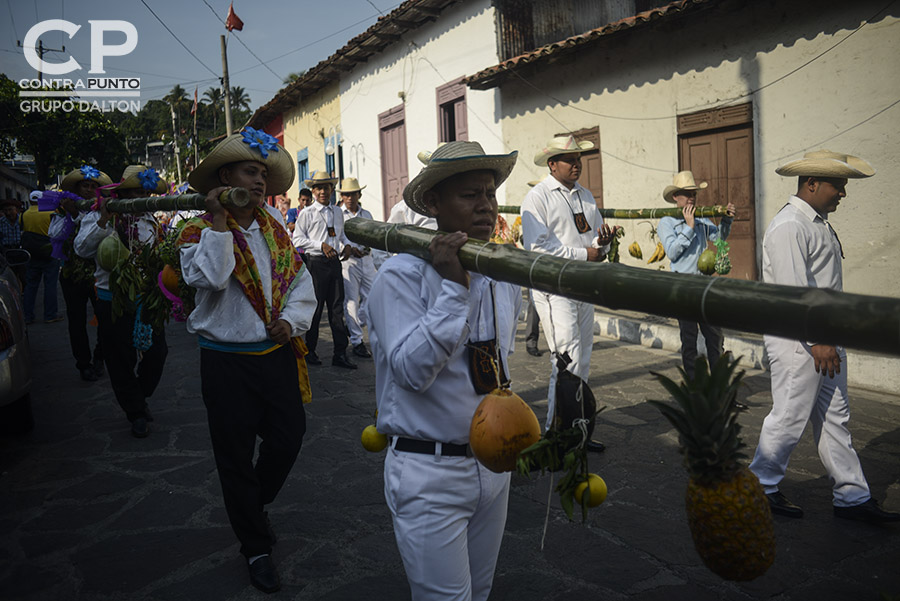 Jóvenes cargan palancas con fruta para  agradecer las cosechas. Cada 3 de mayo los habitantes de Panchimalco, al sur de San Salvador,  rinden  tributo a la Santa Cruz, para agradecer por las cosechas cuya siembra se aproxima junto con la estación lluviosa. En una mezcla de fervor religioso con las tradiciones  de los pueblos originarios.