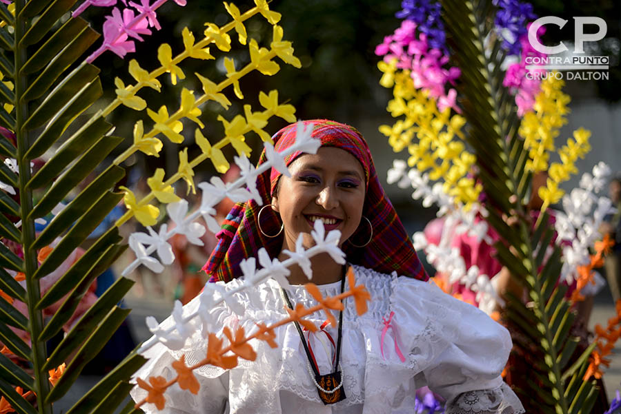 Jóvenes portan palmas con flores en agradecimiento a la naturaleza. Cada 3 de mayo los habitantes de Panchimalco, al sur de San Salvador,  rinden  tributo a la Santa Cruz, para agradecer por las cosechas cuya siembra se aproxima junto con la estación lluviosa. En una mezcla de fervor religioso con las tradiciones  de los pueblos originarios.