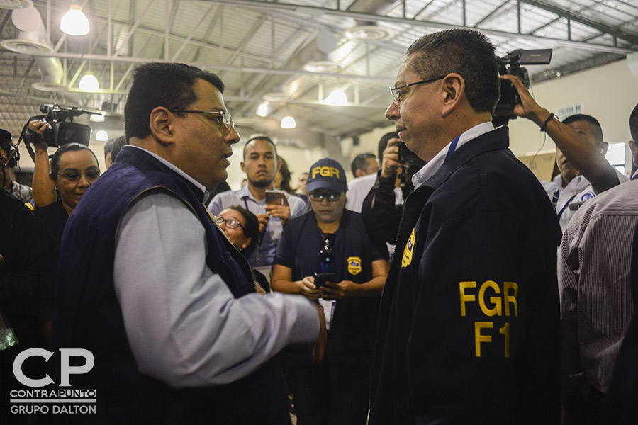 El presidente del Tribunal Supremo Electoral (TSE), Julio Olivo, saluda al fiscal General, Douglas Meléndez, en el pabellón 1 del Centro Internacional de Ferias y Convenciones (CIFCO), el desarrollo de las elecciones municipales y legislativas.