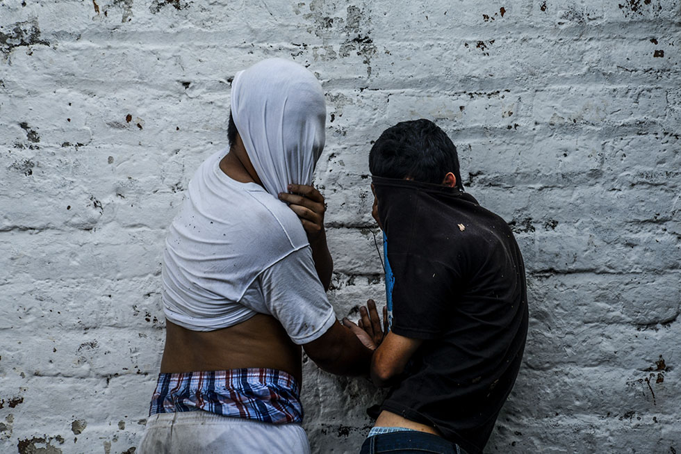 Dos menores de edad, acusados de pertenecer a estructuras delincuenciales que operan en la zona de la colonia Escalón esperan a ser presentados por las autoridades. Foto: Vladimir Chicas